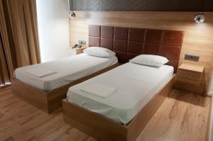 A bed or beds in a room at Metropolis Hotel