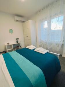 a large blue bed in a room with a window at Villa Petra - Πέτρα in Alpignano