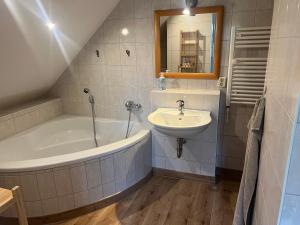 a bathroom with a bath tub and a sink at Am Oberpark in Bad Muskau