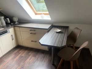 a kitchen with a table and chairs and a skylight at Am Oberpark in Bad Muskau +3 photos