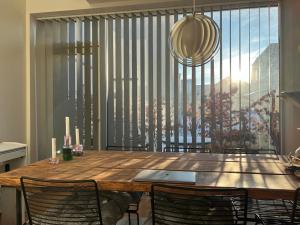 a dining room table with chairs and a large window at Cozy little house in Aalborg +13 photos