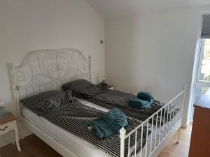 a white bed with two towels on top of it at Cozy little house in Aalborg