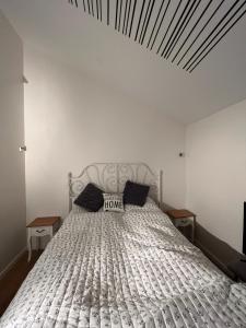 a bedroom with a white bed with two black pillows at Cozy little house in Aalborg