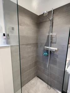 a shower with a glass door in a bathroom at Cozy little house in Aalborg