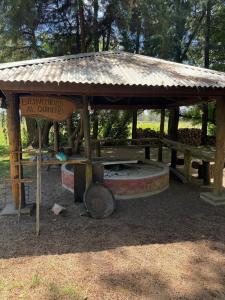 a wooden pavilion with a sign in a park at La rosadita in San Clemente del Tuyú +2 photos