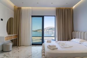 a bedroom with a bed with a view of the water at Day Lux Superior Apartments in Sarandë