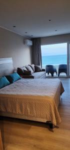 a bedroom with a large bed and a couch at Quequen - Vista al Mar in Quequén