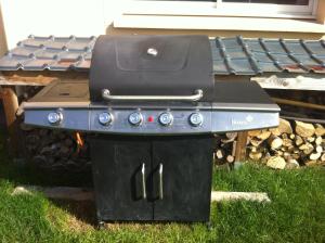 a grill sitting in the grass in front of a house at Maison Reine-Claude in Esbly
