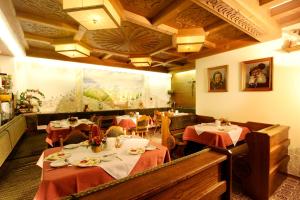 a restaurant with two tables with red table cloth at Gästeheim Prantl in Sölden