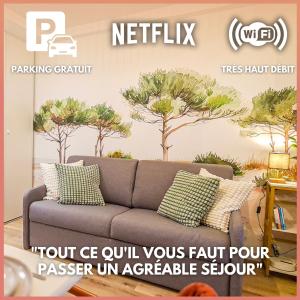a booth with a couch and trees on the wall at A L'ombre des Pins, Appartement neuf, élégant, Parking gratuit, Netflix, au calme à 100m de l'océan in Les Sables-dʼOlonne