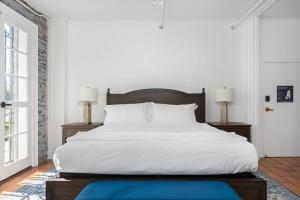 a bedroom with a large white bed with two lamps at Deluxe King Suite at the Historic Stonehouse Inn! in Santa Rosa