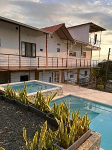 a resort with a swimming pool and a building at Alojamiento rural san joaquin in Quimbaya