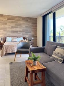 un salon avec un canapé et un lit dans l'établissement Chic Loft Steps from the Beach, à Holbox