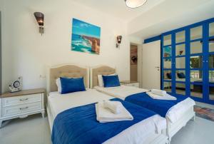 2 letti in una camera da letto con blu e bianco di Villa Yakamoz a Fethiye Altre 21 foto