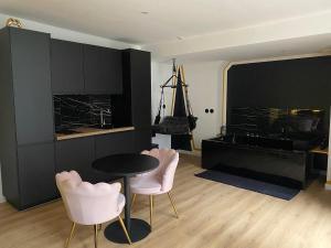 a living room with a table and two chairs at Love room Spa "Trésor des Anges" in Rouen +10 photos