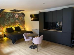 a bedroom with a bed and a table and chairs at Love room Spa "Trésor des Anges" in Rouen