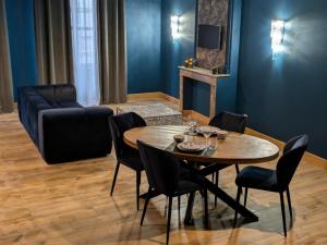 a living room with a table and chairs and a couch at Bliss in Langres