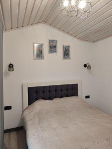 a bedroom with a large bed in a white room at Family House Volosianka in Volosyanka