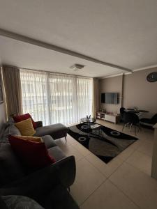 a living room with a couch and a piano at 1 Bedroom Marina Bay Apartment 7 in Durban