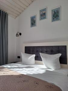 a bedroom with a bed with white sheets and pillows at Family House Volosianka in Volosyanka