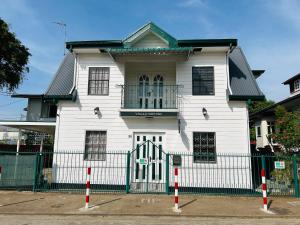 a white house with a fence in front of it at Villa Josephine in Paramaribo