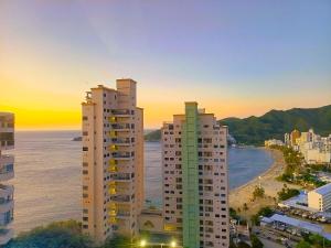 a view of two tall buildings and the ocean at Exclusivos apartasuites Ambar Roca - Rodadero in Santa Marta
