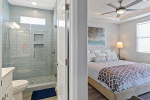 una camera da letto con un letto e una doccia in vetro di Bella Luna - Stunning 4BR Beachfront w Cargo Lift a Bolivar Peninsula Altre 116 foto