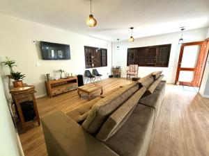 een woonkamer met een grote bank in het midden bij Pousada Essência de Minas in São Lourenço
