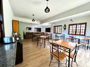 een kamer met tafels en stoelen en een woonkamer bij Pousada Essência de Minas in São Lourenço