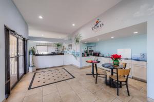 a kitchen with a counter and a table and chairs at Dunes Inn & Suites - Tybee Island in Tybee Island