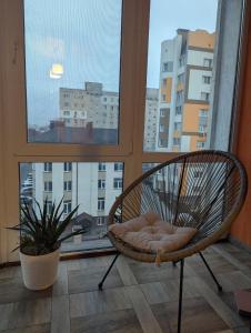 a wicker chair sitting in front of a window at 2-кім Новобудова, центр, провулок Лапушкіна , 9 in Khmelʼnytsʼkyy