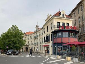 a man crossing a street in front of a building at Le Bristol - Gîtes Canal & Chenier, proche gare in Carcassonne