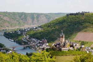 eine Burg auf einem Hügel neben einem Fluss in der Unterkunft Hotel am Hafen in Cochem