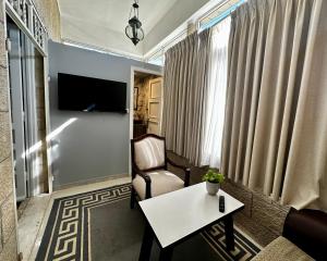 a living room with a couch and a table and a tv at Beit Ahlan in Amman