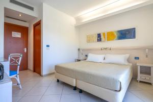 a bedroom with a bed and a table and a chair at Elaia Garden Hotel in Sperlonga