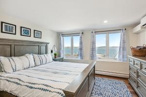 a bedroom with a bed and two windows at Lakeshore Vermont in Colchester