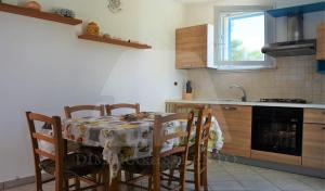 a kitchen with a table and chairs and a kitchen with a sink at Casa della baia in Marina San Gregorio