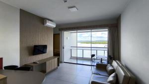 Una sala de estar con un sofá y una ventana grande. en Praias do Lago Eco Resort by WAM Experience, en Caldas Novas