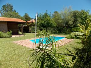 una piscina en un patio al lado de una casa en La cabañita de Maco, en Nono