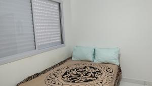 a dog bed in a room with a window at Avelinos praia mar in Guarujá