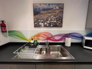 a dish drying rack next to a sink in a kitchen at Glastonbury Sacred Vault, Split-Level, 1 Bedroom in Glastonbury