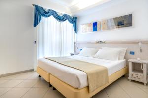 a bedroom with a large bed and a window at Elaia Garden Hotel in Sperlonga