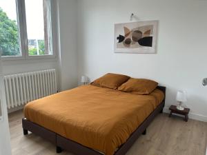 a bed in a white room with two windows at Appart hôtel Doumer in Triel-sur-Seine