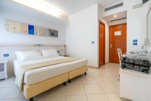 a bedroom with a bed and a desk in it at Elaia Garden Hotel in Sperlonga