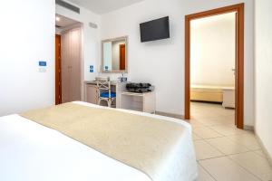 a hotel room with a bed and a bathroom at Elaia Garden Hotel in Sperlonga