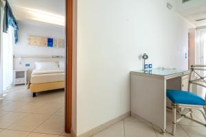 a hospital room with a bed and a desk and a mirror at Elaia Garden Hotel in Sperlonga