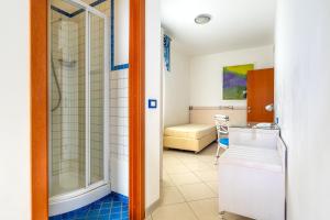 a bathroom with a shower and a bedroom at Elaia Garden Hotel in Sperlonga