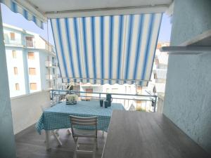 a table and chairs on a balcony with a blue and white curtain at Dima Home Scalea in Scalea
