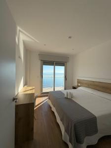 a bedroom with a large bed and a large window at Apartamentos O Grove Awa Bay in O Grove +37 photos
