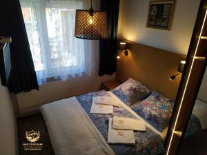 a bedroom with a bed with towels on it at "Nad Zdrojami" Pokoje Kowalczyk in Szczawnica